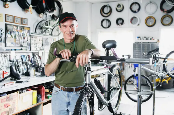 Portrait of man repairing bike in bike shop