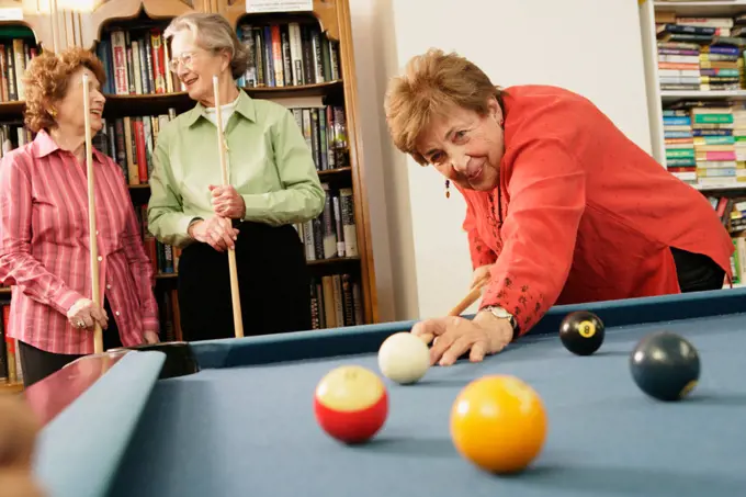 Elderly woman shooting pool