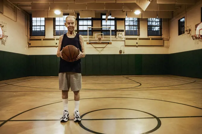 Elderly man standing in basketball court