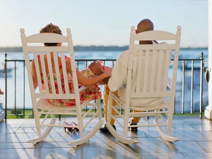 Rear view of couple sitting on deck