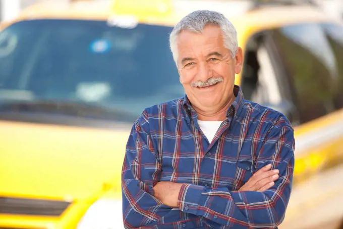 Middle Eastern man posing in front of taxi