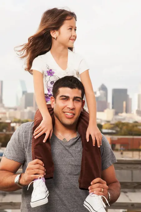 Father carrying daughter on shoulders