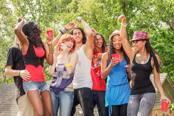 Friends dancing and drinking together