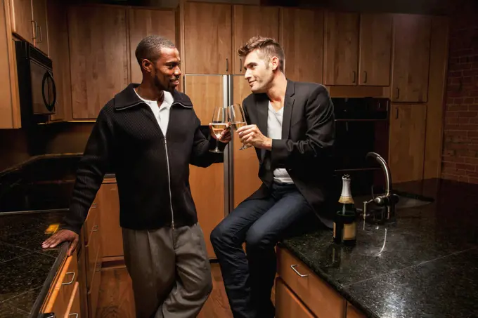 Gay couple drinking wine in kitchen