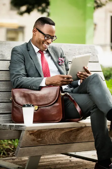 Black businessman using digital tablet outdoors