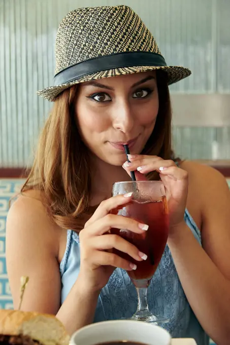 Teenager drinking beverage with straw