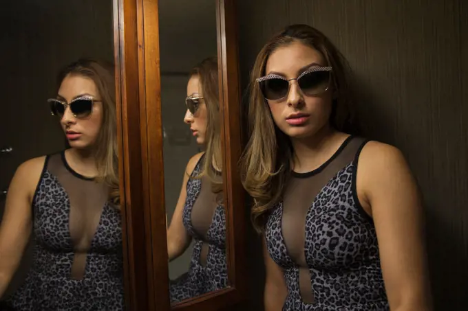 Teenager wearing sunglasses near mirror