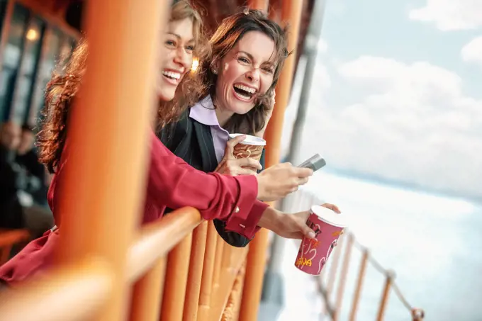 Businesswoman leaning on railing of commuter ferry