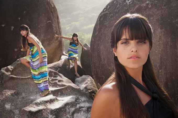 Multiple image of Hispanic woman on rocks