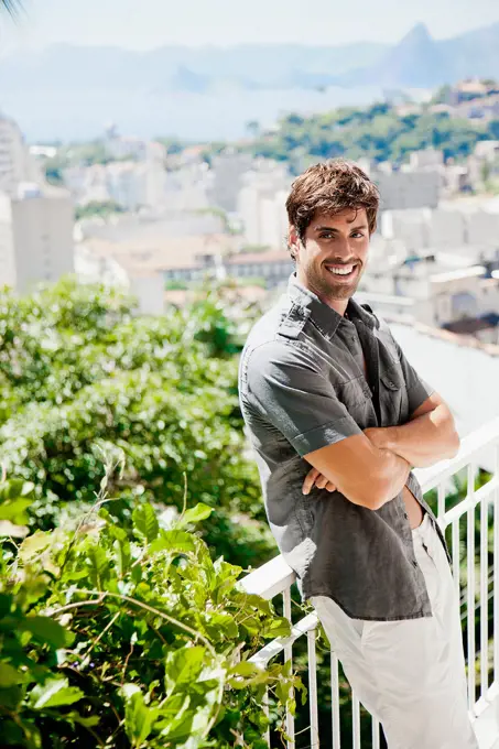 Hispanic man leaning on urban railing