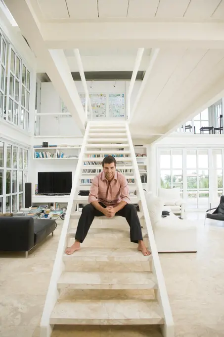 Hispanic man smiling on staircase