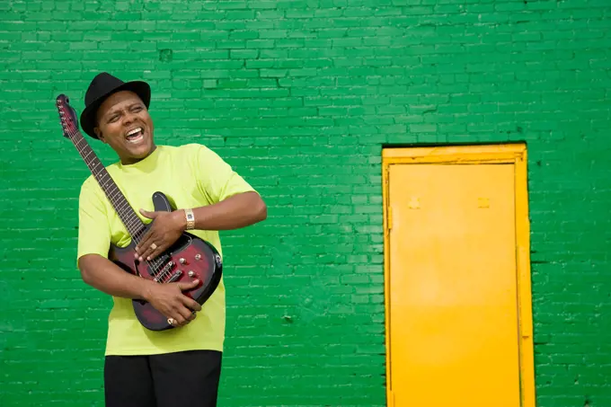 African musician holding electric guitar