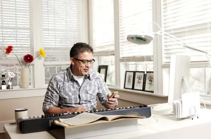 Hispanic man with electronic keyboard and cell phone