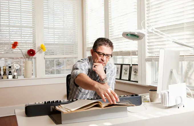 Hispanic man with electronic keyboard and sheet music