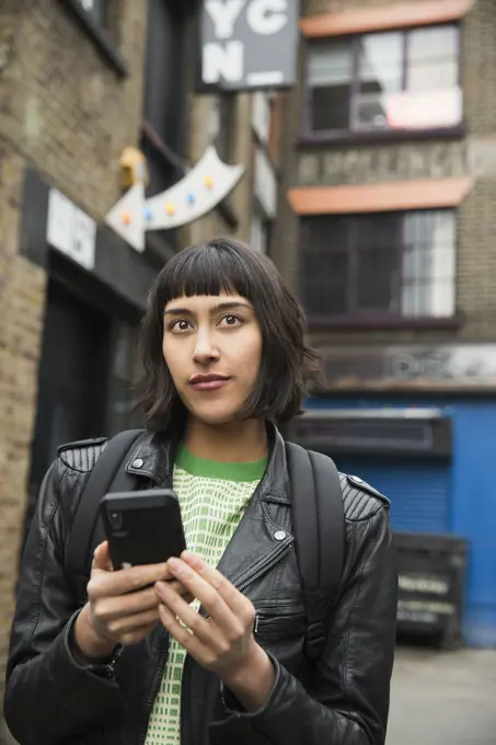 Woman walking the streets of London using mobile phone