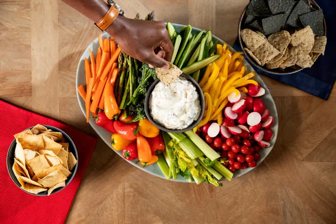 Overhead shot of one person dipping a chip in to sour cream