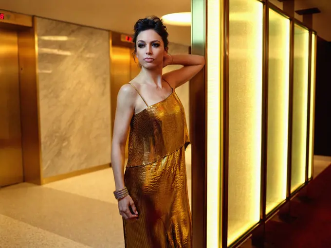 Portrait of a woman waiting for an elevator, looking off camera.