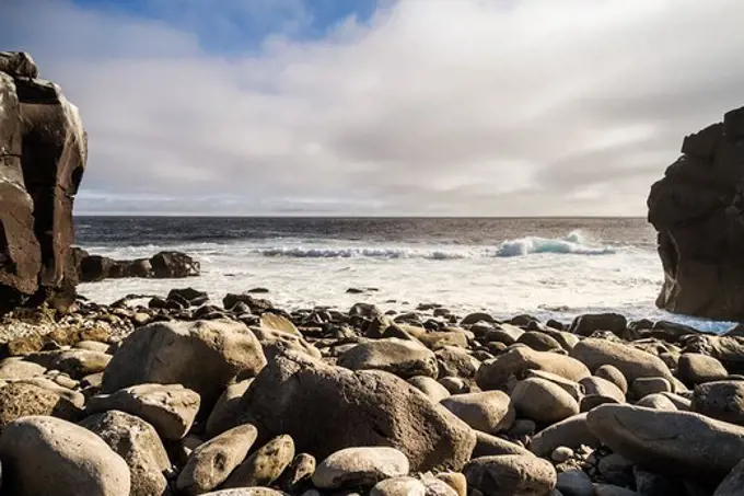 Ecuador, Galapagos Islands, surf crashing on rocky beach