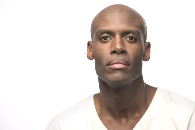 Portrait of young bald African American man looking at  camera with straight face 