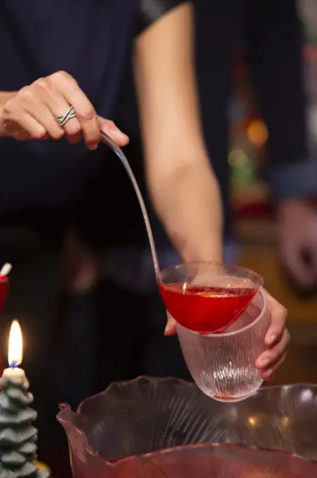 Detail of woman filling cup  from punch bowl at festive Christmas party