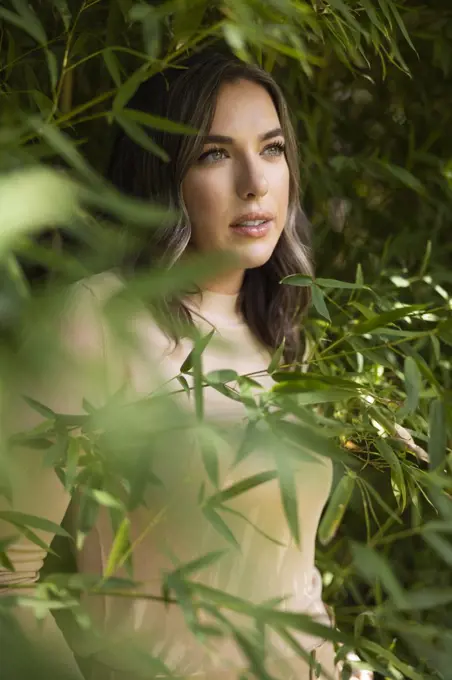 Portrait of caucasian woman  standing among bamboo 