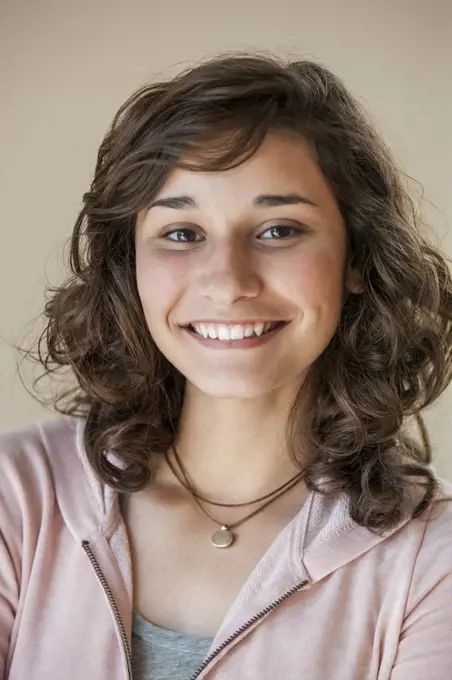 Portrait of a young Hispanic woman looking into camera with confident smile. 