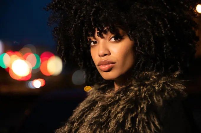 Confident portrait of a young African American in the city at night. 