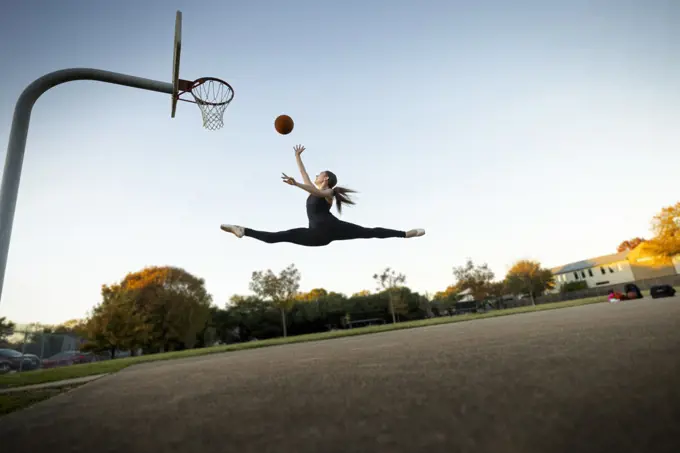 Ballet dancer playing basketball on an outdoor court