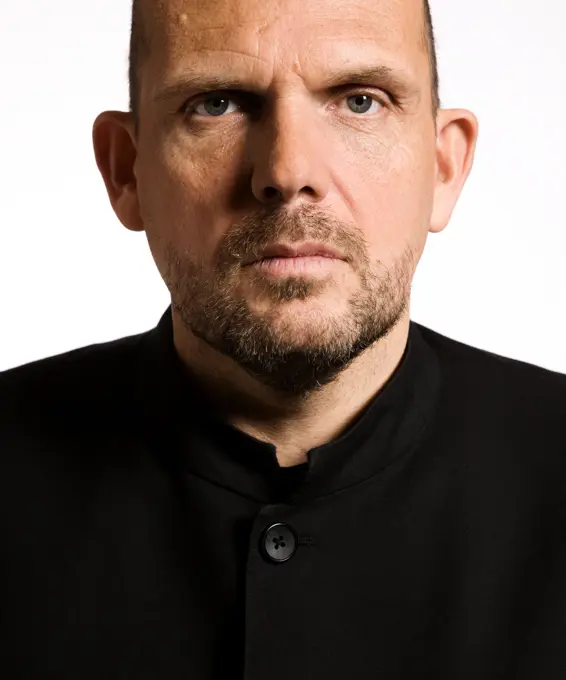 Close up portrait of conductor Jaap van Zweden staring directly into camera lens on white background at The Morton H. Meyerson Symphony Center,  Orchestra concert hall located in the Arts District of downtown Dallas, Texas.