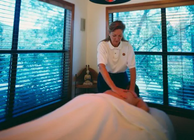 Massage therapist giving massage to her client