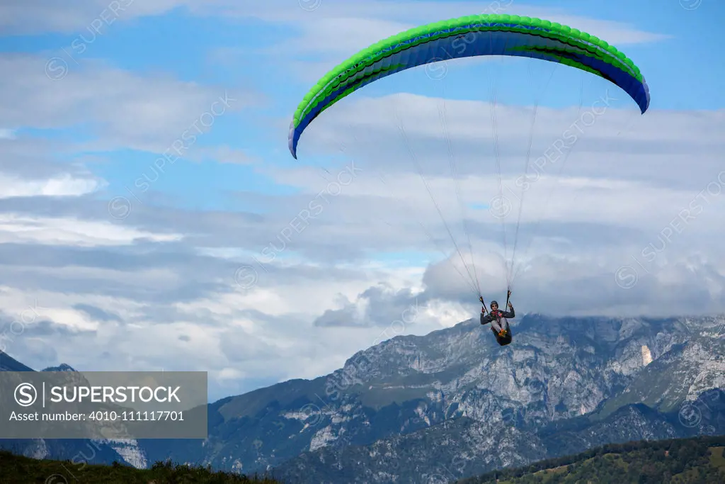 Caucasian man paragliding over remote mountains