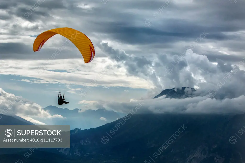 Caucasian man paragliding over remote mountains