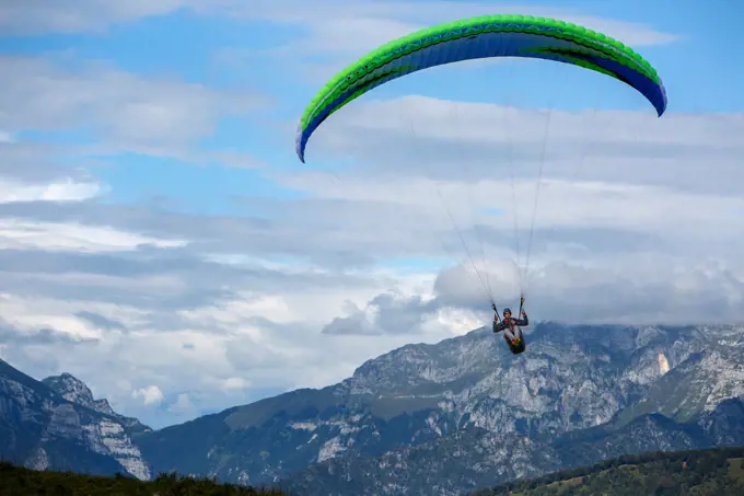 Caucasian man paragliding over remote mountains