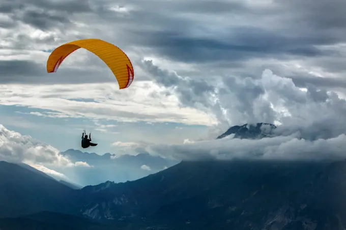 Caucasian man paragliding over remote mountains