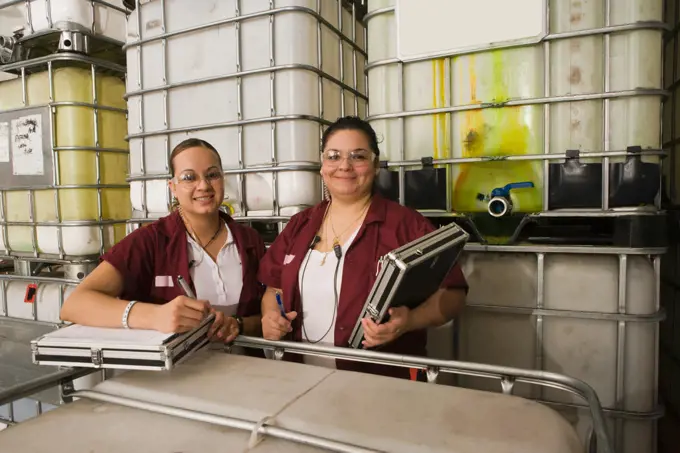 Hispanic women smiling in manufacturing plant