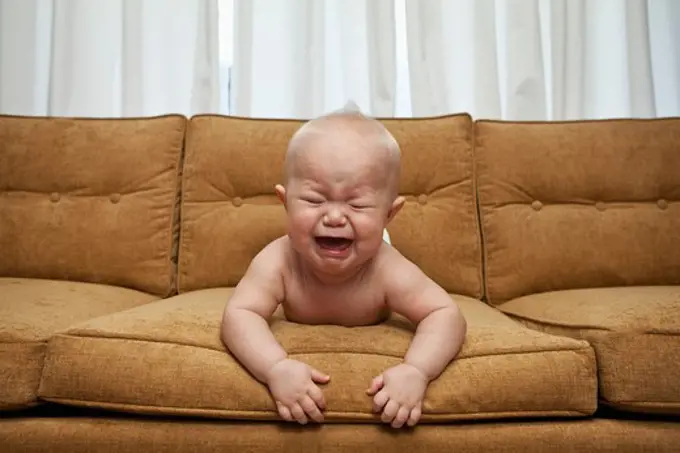 Seven month old baby on couch crying