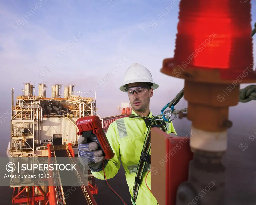 Gas platform worker testing a safety light on a gas platform