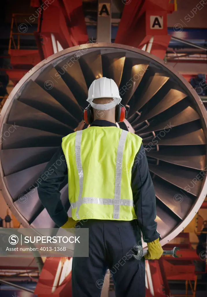 Aeronautic engineer standing in front of an airplane engine