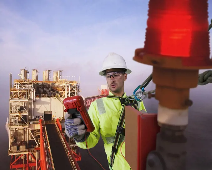 Gas platform worker testing a safety light on a gas platform