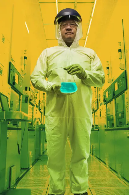 Lab technician holding up liquid solution in clean room