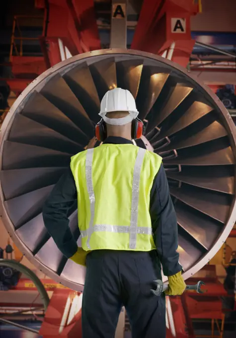 Aeronautic engineer standing in front of an airplane engine