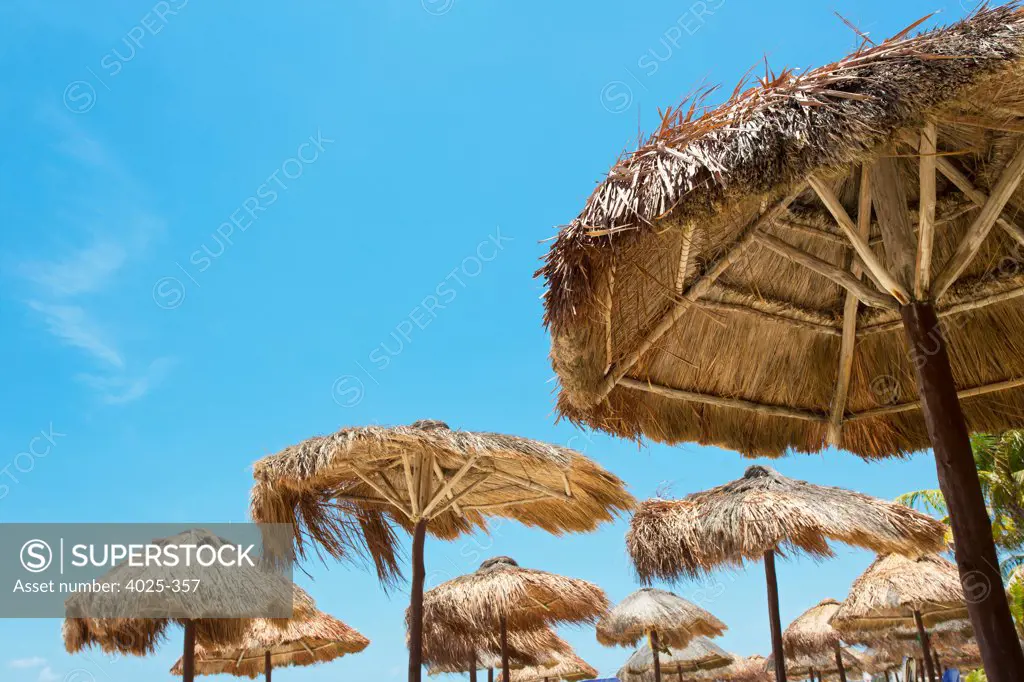 Mexico, Playa del Carmen, Group of palapas against blue sky