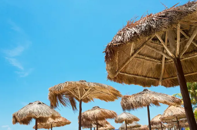 Mexico, Playa del Carmen, Group of palapas against blue sky