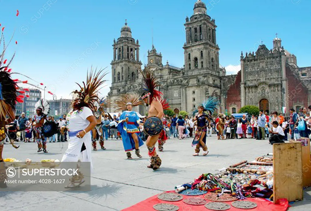 Aztec performers dance in Zocalo Square in front of Metropolitan Cathedral and the Metropolitan Sagrario in Mexico City, Mexico