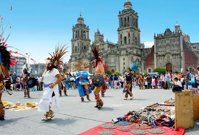 Aztec performers dance in Zocalo Square in front of Metropolitan Cathedral and the Metropolitan Sagrario in Mexico City, Mexico