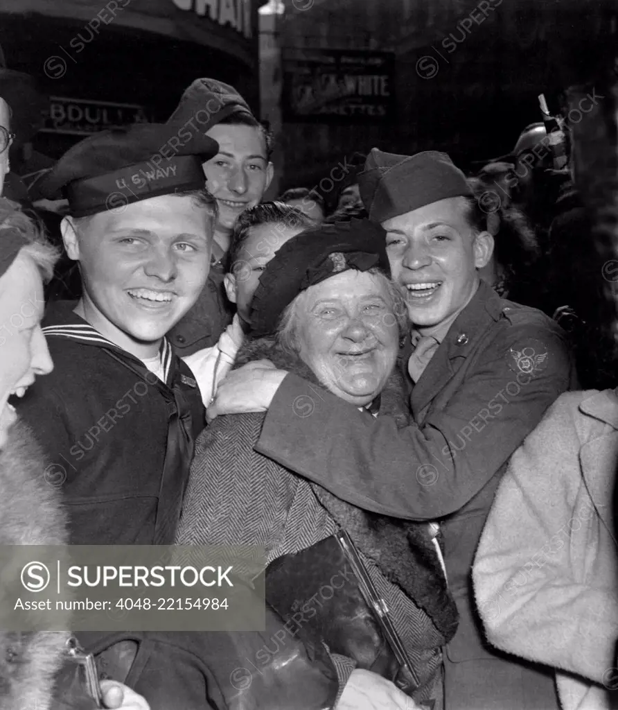 V-E Day celebration in Piccadilly Circus, London, May 7, 1945. A jubilant American soldier hugs a motherly English woman celebrating Germany's unconditional surrender. World War 2. (BSLOC_2014_8_105)