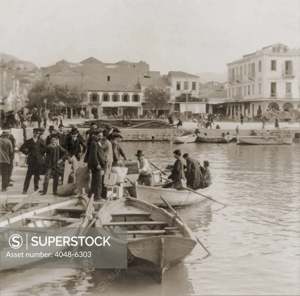 Greek immigrants, all men, embarking in small boat for asteamer that will take them to America. Patras, Greece. Ca. 1910.
