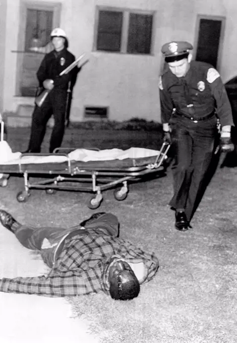 March 1966 Watts Riot. A sniper killed two in Watts section of Los Angeles. Ambulance attendants pick up the body of African American, Joe Crawford, 33, one of two Watts men killed by a sniper at an intersection. March 15, 1966.