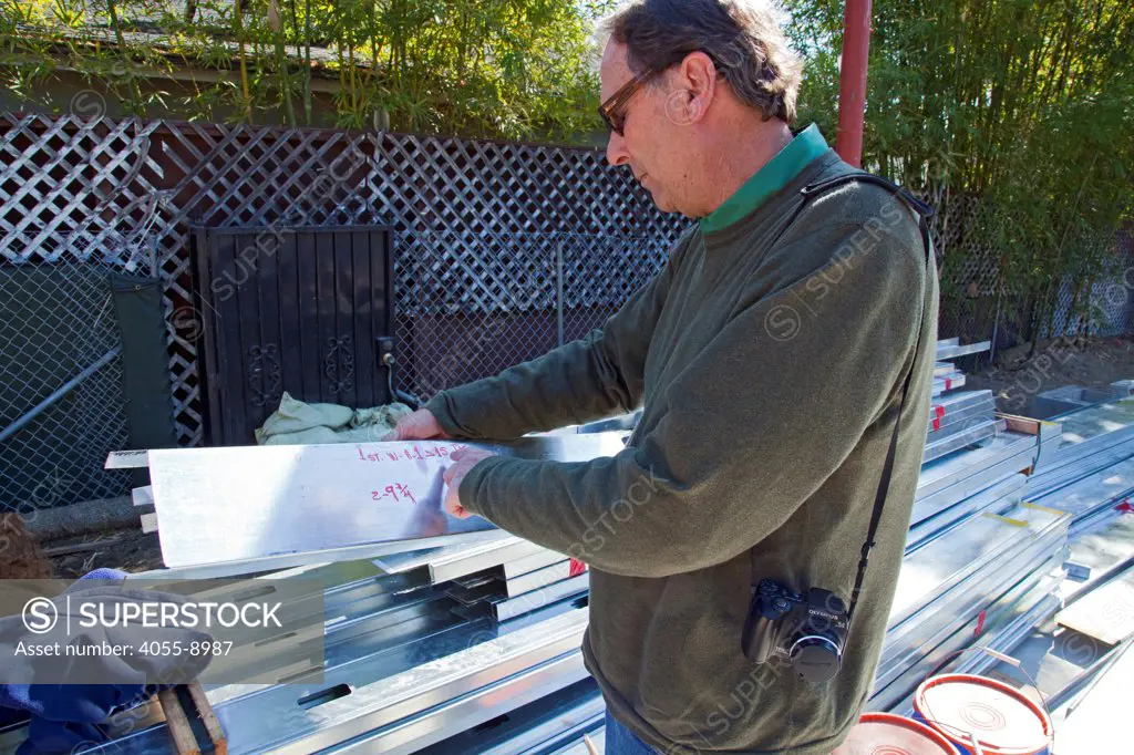 Donald Wheeler, steel framing contractor displaying 18 gauge steel. On 2/13/2013 the steel framing continues to be assembled over the foundation on the Begley's new home. Steel, while not a common material for residential framing, is 94% recyclable, has been milled locally for this project, and is a more sustainable choice than wood, which is typically used for residential building construction. Studio City, California, USA