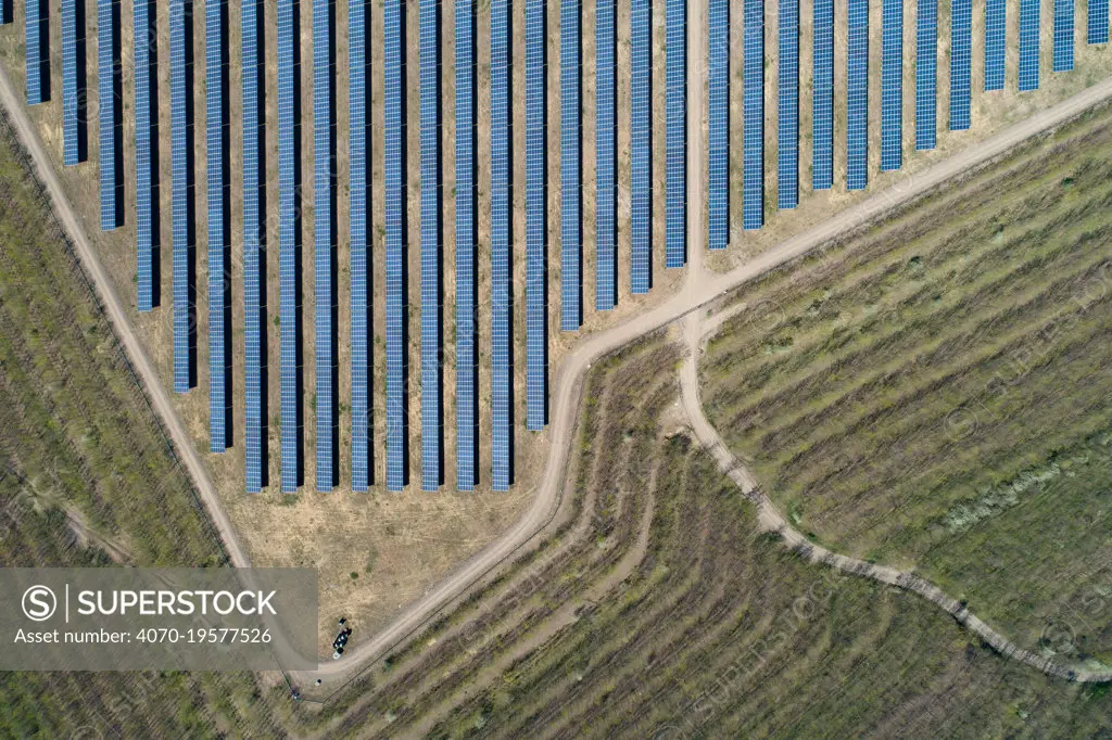 Aerial view of solar panels on top of a coal ash pyramid in East-Central Europe. After coal is burned in power plants, the waste ash is stacked and compacted into large pyramids, which may eventually be covered over with solar panels, trees or even grape plantations. The pyramids are used as landfill to prevent the release of ash into the atmosphere, but they also contaminate the environment with toxic pollutants harmful to human health.